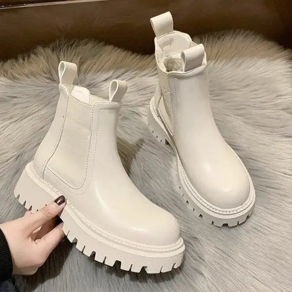 White chunky-sole leather boots with pull tabs displayed on soft fur background